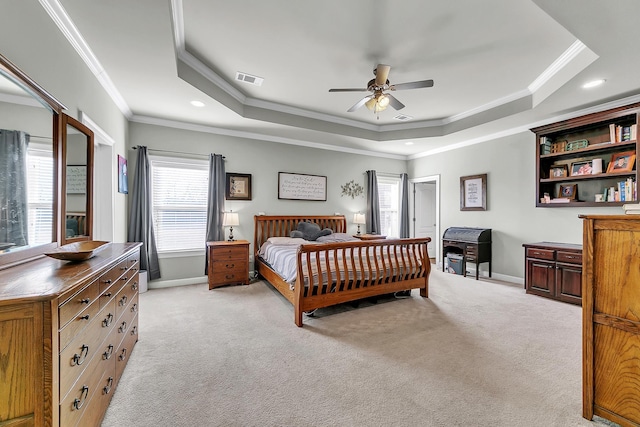 bedroom featuring a raised ceiling, light colored carpet, and baseboards