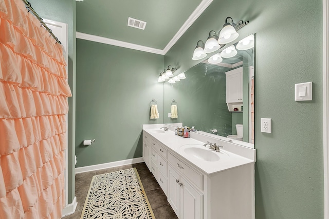 bathroom featuring baseboards, crown molding, visible vents, and a sink