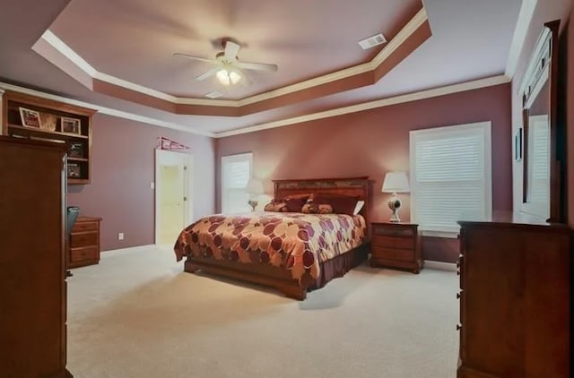 bedroom featuring baseboards, visible vents, a raised ceiling, crown molding, and carpet floors