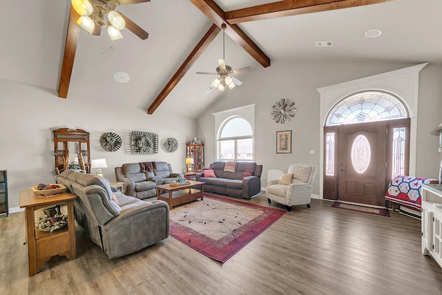 living room featuring visible vents, a ceiling fan, wood finished floors, beamed ceiling, and high vaulted ceiling