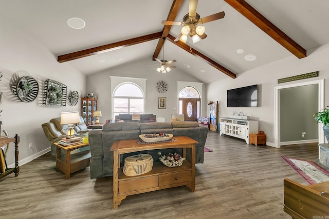 living area featuring beamed ceiling, baseboards, and wood finished floors