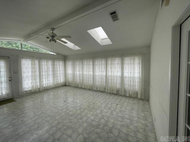 spare room featuring lofted ceiling with skylight and ceiling fan