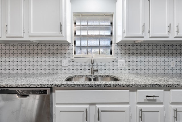 kitchen featuring dishwasher, sink, light stone countertops, and white cabinets