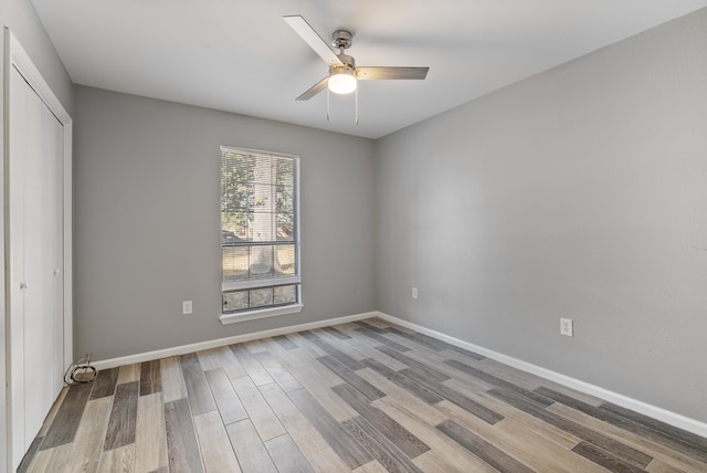 unfurnished bedroom with hardwood / wood-style flooring, ceiling fan, and a closet