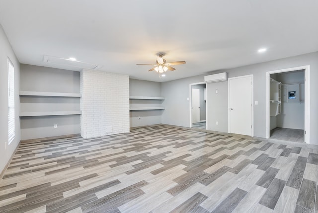 unfurnished living room featuring light hardwood / wood-style floors, an AC wall unit, and ceiling fan