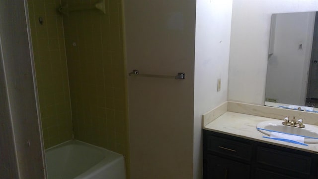 bathroom featuring tiled shower / bath and vanity