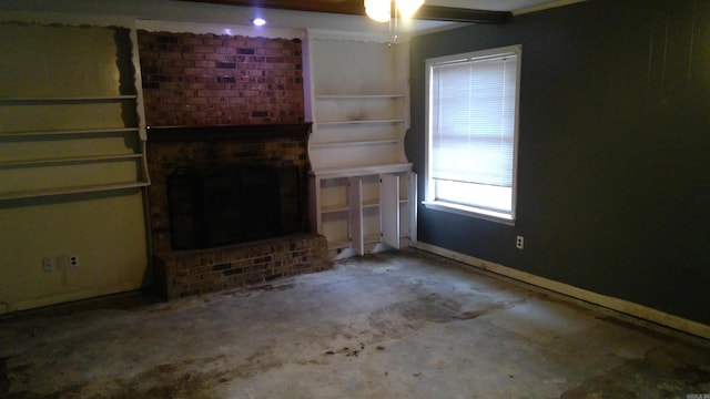 unfurnished living room with a brick fireplace and concrete flooring