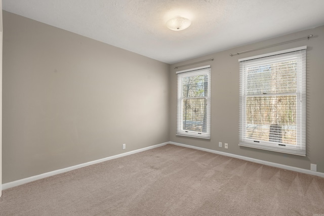 spare room with light carpet and a textured ceiling