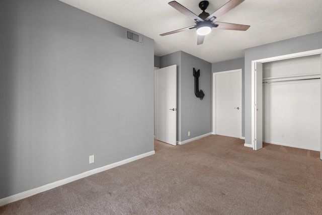 unfurnished bedroom featuring ceiling fan, a closet, and light carpet