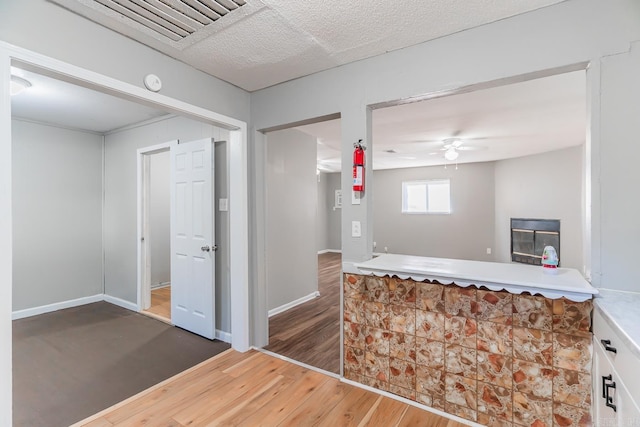 kitchen with dark hardwood / wood-style flooring, a fireplace, and ceiling fan