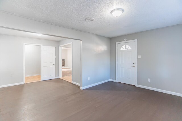 foyer entrance featuring dark hardwood / wood-style flooring and a textured ceiling