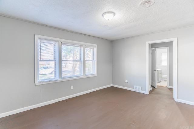 unfurnished room featuring wood-type flooring and a textured ceiling