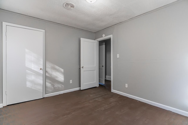 unfurnished room with dark hardwood / wood-style flooring and a textured ceiling