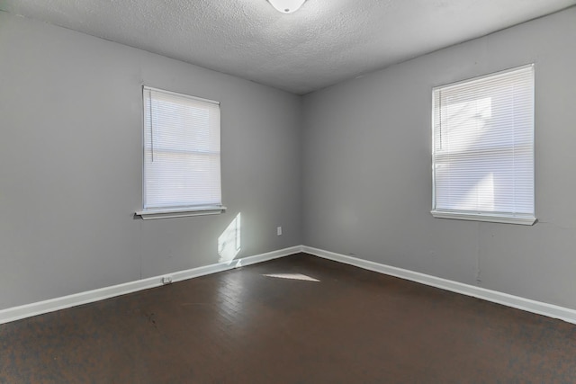 spare room with hardwood / wood-style flooring and a textured ceiling