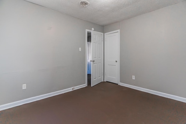 unfurnished room featuring a textured ceiling