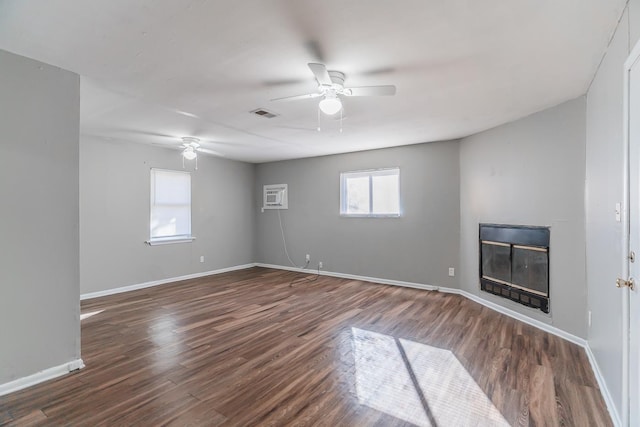 interior space featuring ceiling fan, a wall mounted air conditioner, and dark hardwood / wood-style floors