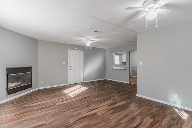 unfurnished living room with dark hardwood / wood-style floors and ceiling fan