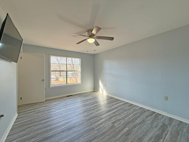 spare room with ceiling fan and wood-type flooring