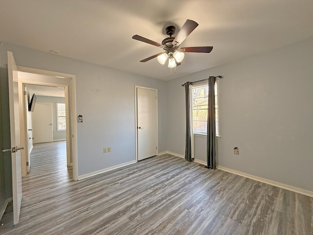 unfurnished bedroom with multiple windows, light hardwood / wood-style flooring, and ceiling fan