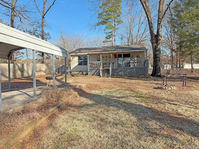 view of front of home featuring a carport, covered porch, and a front lawn