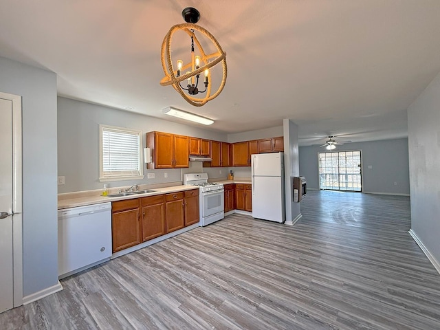 kitchen with plenty of natural light, sink, pendant lighting, and white appliances