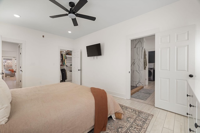 bedroom with light hardwood / wood-style flooring, ceiling fan, washer / clothes dryer, a spacious closet, and a closet