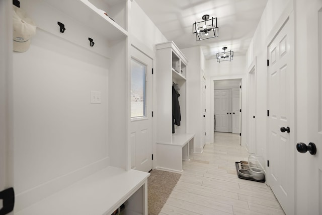 mudroom with a notable chandelier and light hardwood / wood-style floors