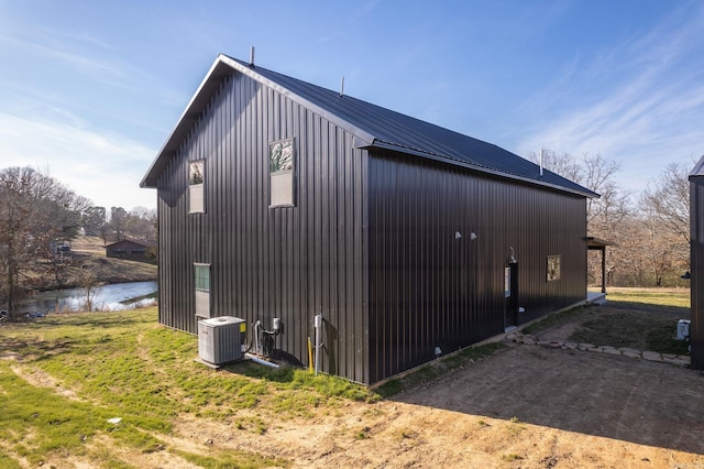 view of property exterior with cooling unit and a water view