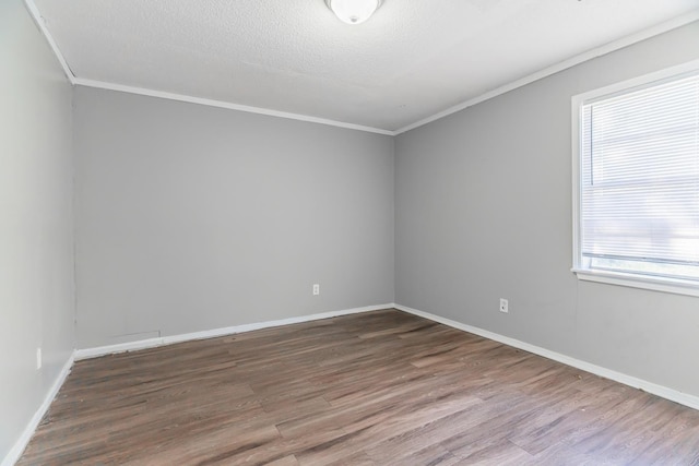 empty room with hardwood / wood-style flooring, crown molding, and a textured ceiling