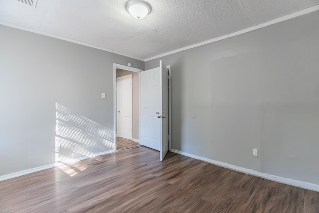 spare room with crown molding, dark wood-type flooring, and a textured ceiling