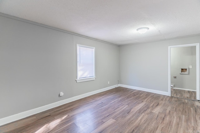 empty room with hardwood / wood-style floors and a textured ceiling