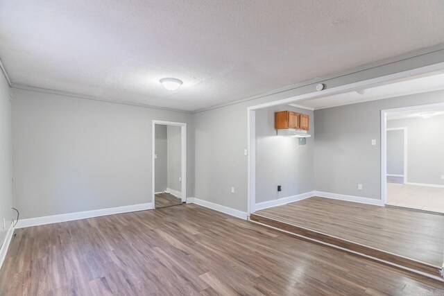 empty room featuring wood-type flooring and a textured ceiling