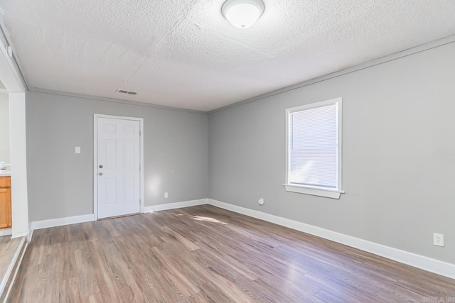 unfurnished room with hardwood / wood-style flooring and a textured ceiling