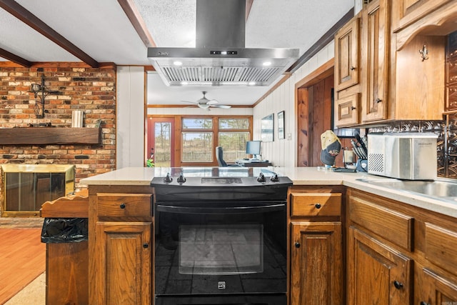 kitchen featuring ventilation hood, electric range, kitchen peninsula, beamed ceiling, and light hardwood / wood-style floors