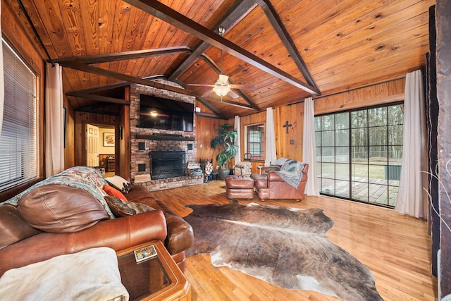 living room featuring vaulted ceiling with beams, wooden ceiling, a brick fireplace, and wood walls