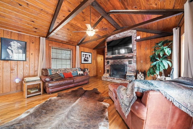 living room featuring wood ceiling, vaulted ceiling with beams, light hardwood / wood-style floors, a brick fireplace, and wood walls