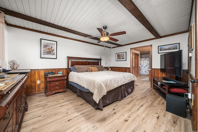 bedroom featuring ceiling fan, wood walls, beamed ceiling, and light wood-type flooring