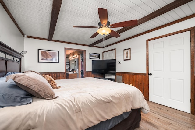 bedroom featuring ceiling fan, wooden walls, beamed ceiling, and light wood-type flooring