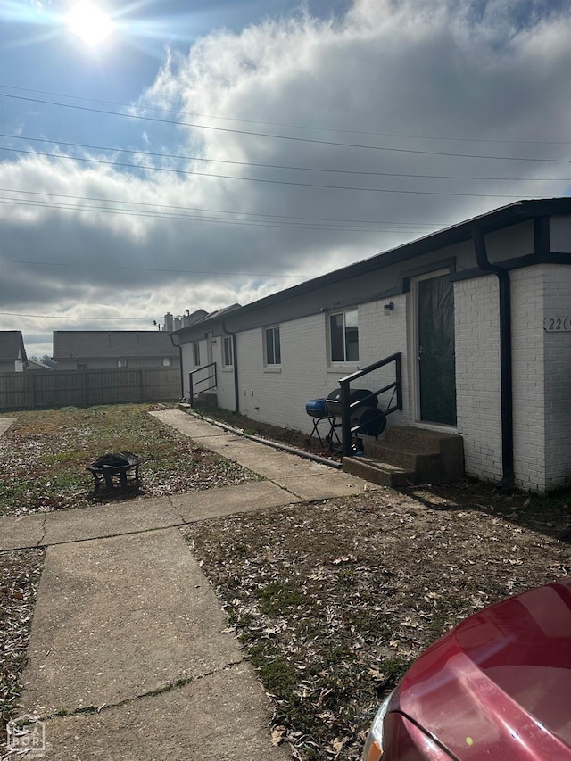 view of side of property featuring an outdoor fire pit