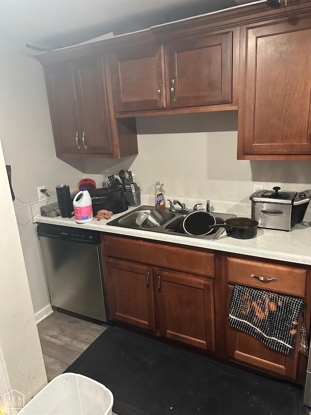 kitchen with hardwood / wood-style flooring, sink, and stainless steel dishwasher