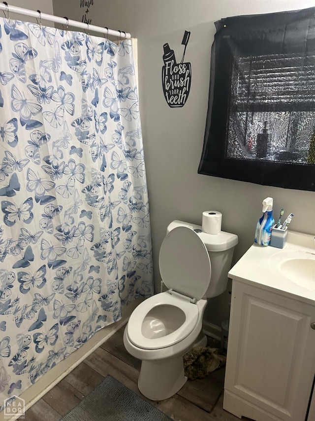 bathroom featuring walk in shower, vanity, toilet, and hardwood / wood-style floors