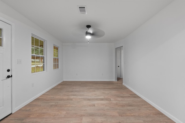 empty room with ceiling fan and light hardwood / wood-style flooring