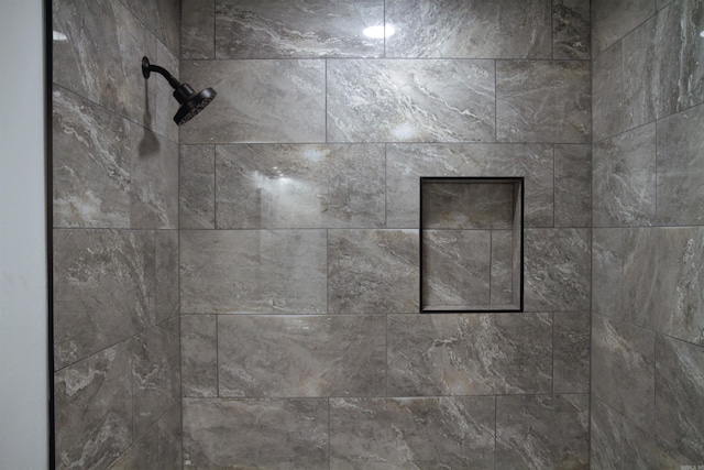 interior details featuring tiled shower