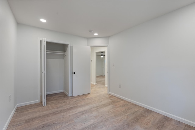 unfurnished bedroom featuring light wood-type flooring and a closet