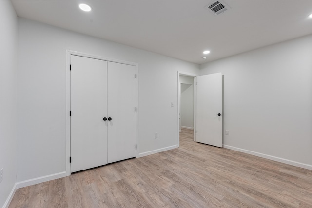 unfurnished bedroom featuring a closet and light wood-type flooring