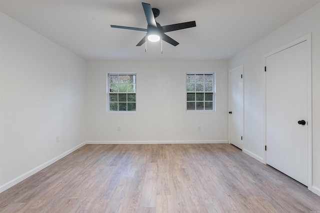 empty room with ceiling fan and light hardwood / wood-style flooring