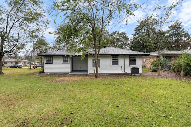 view of front facade featuring a patio, cooling unit, and a front yard