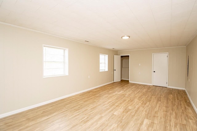 unfurnished room featuring ornamental molding and light hardwood / wood-style flooring