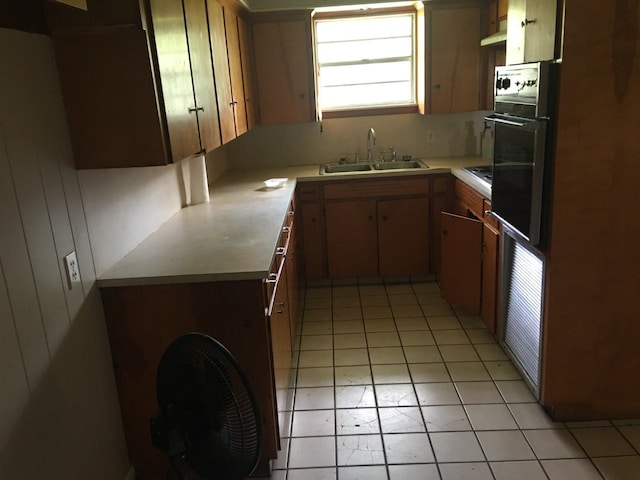 kitchen with sink, light tile patterned floors, and black appliances