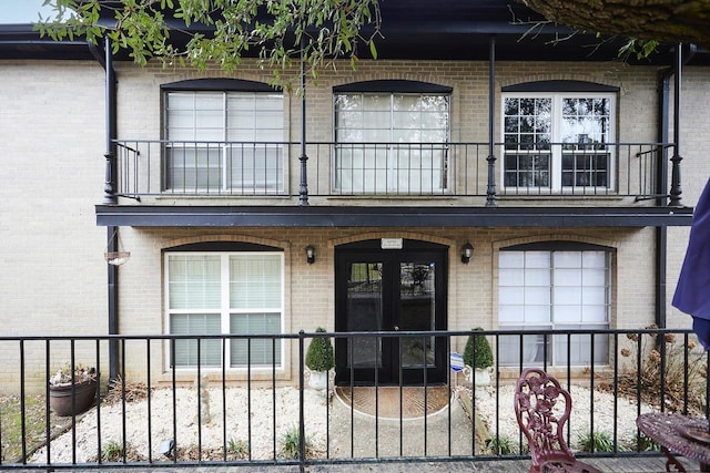 view of front facade featuring a balcony and french doors